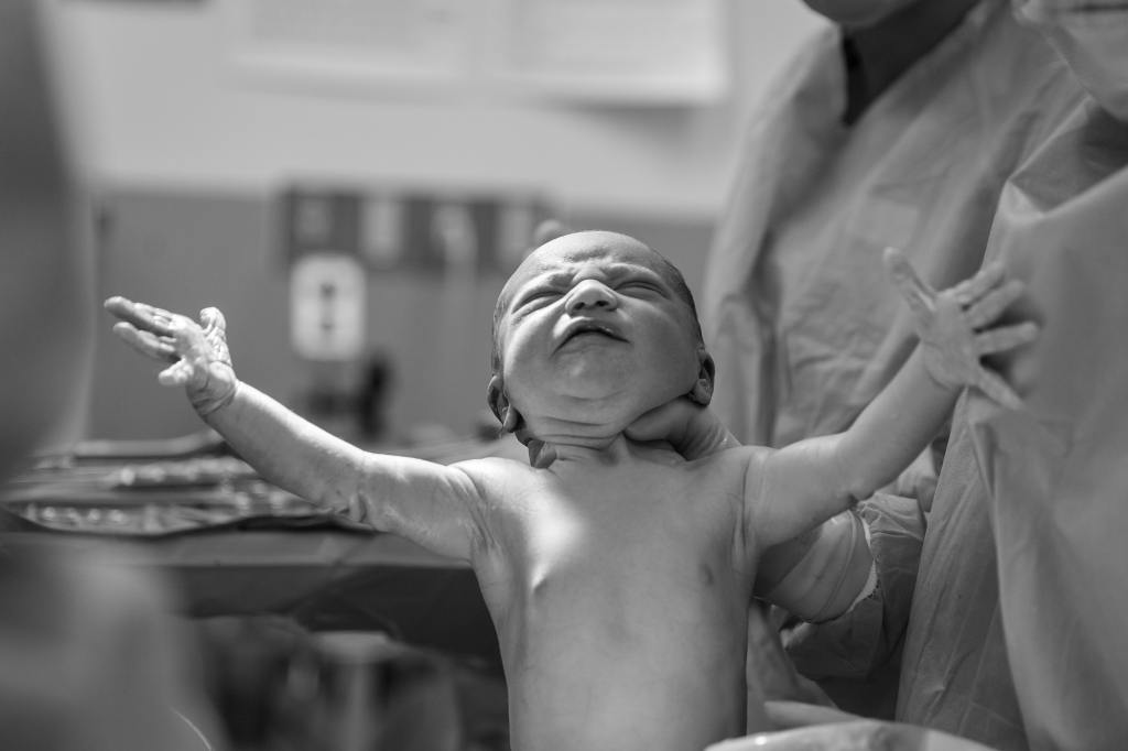 Newborn baby with its arms outstretched